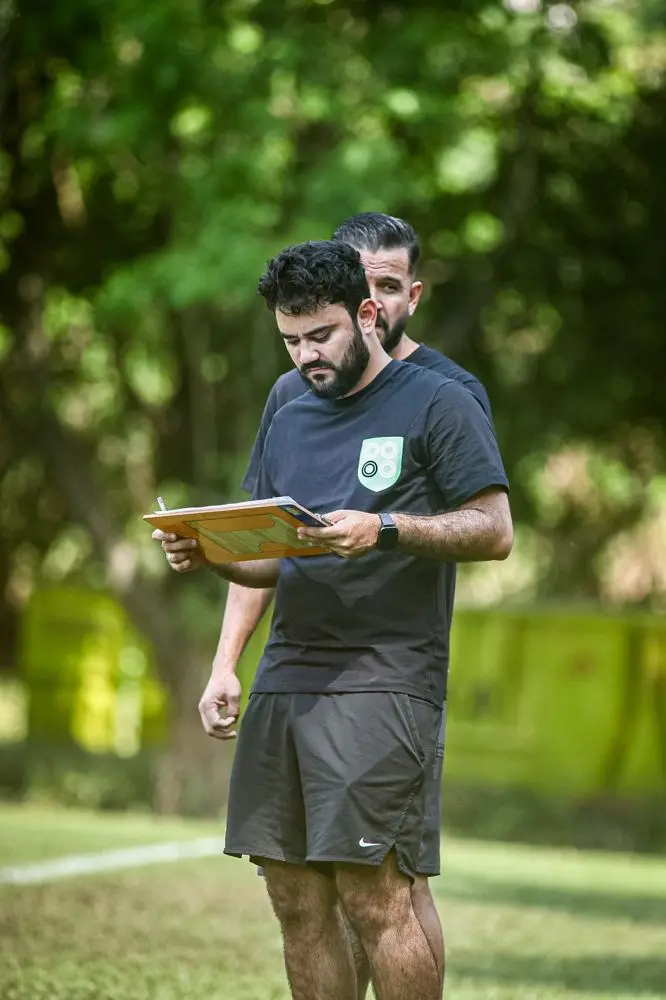 Matheus de Moraes em campo, consultando uma prancheta